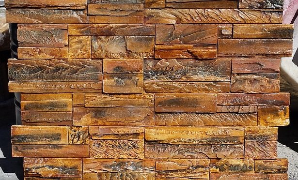 An SBC concrete wall panel in rust and charcoal tones.