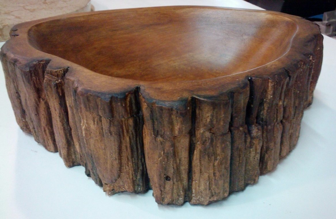 A brown concrete vessel sink with a bark-textured exterior, on white.
